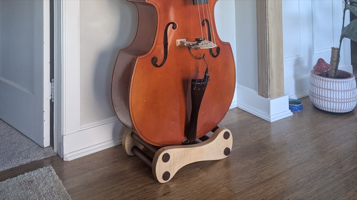 The bass in its home — three-quarter view with wainscoting and fiddle-leaf fig