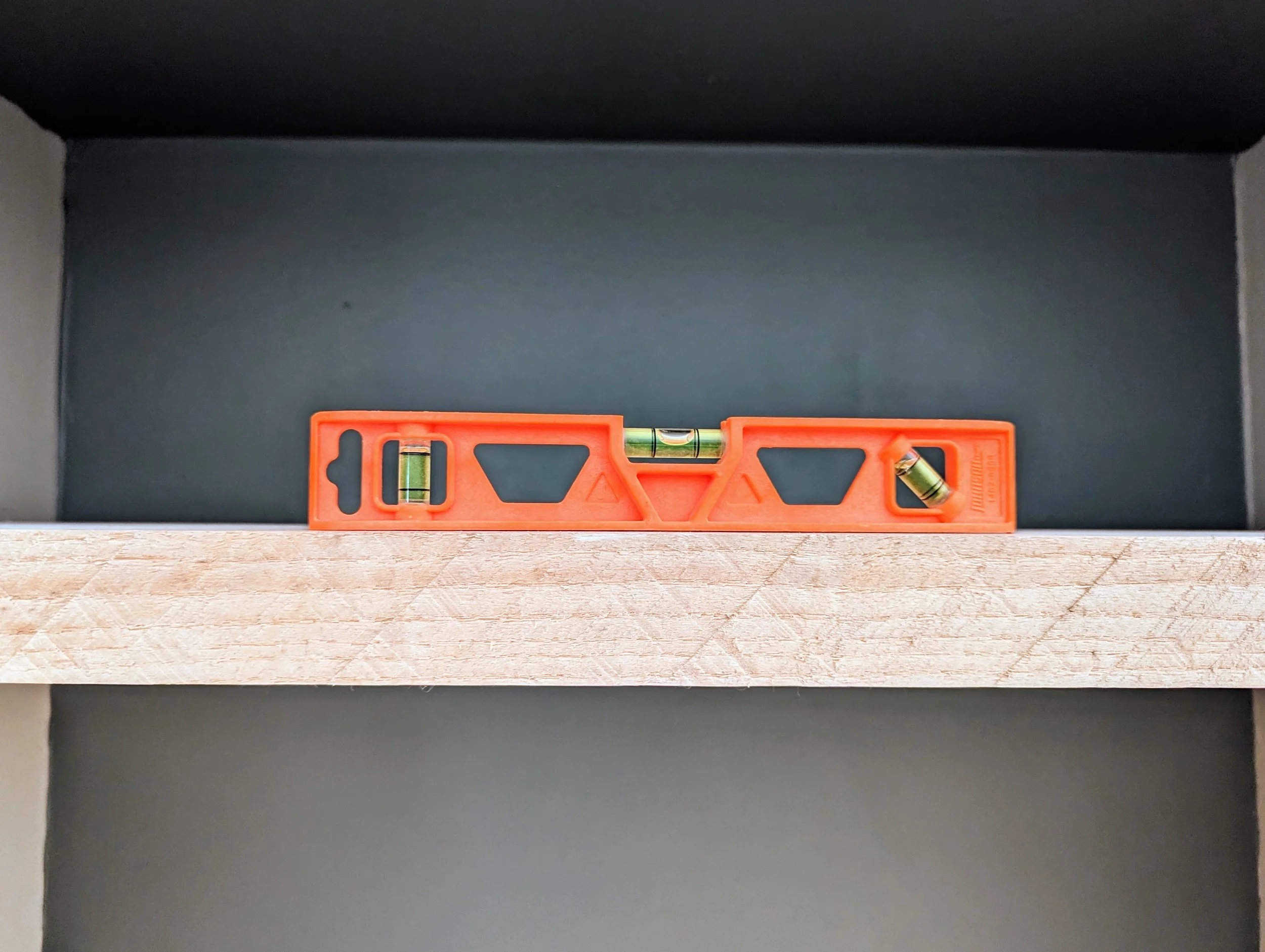 Spirit level showing perfectly level shelf — the supports were awesome