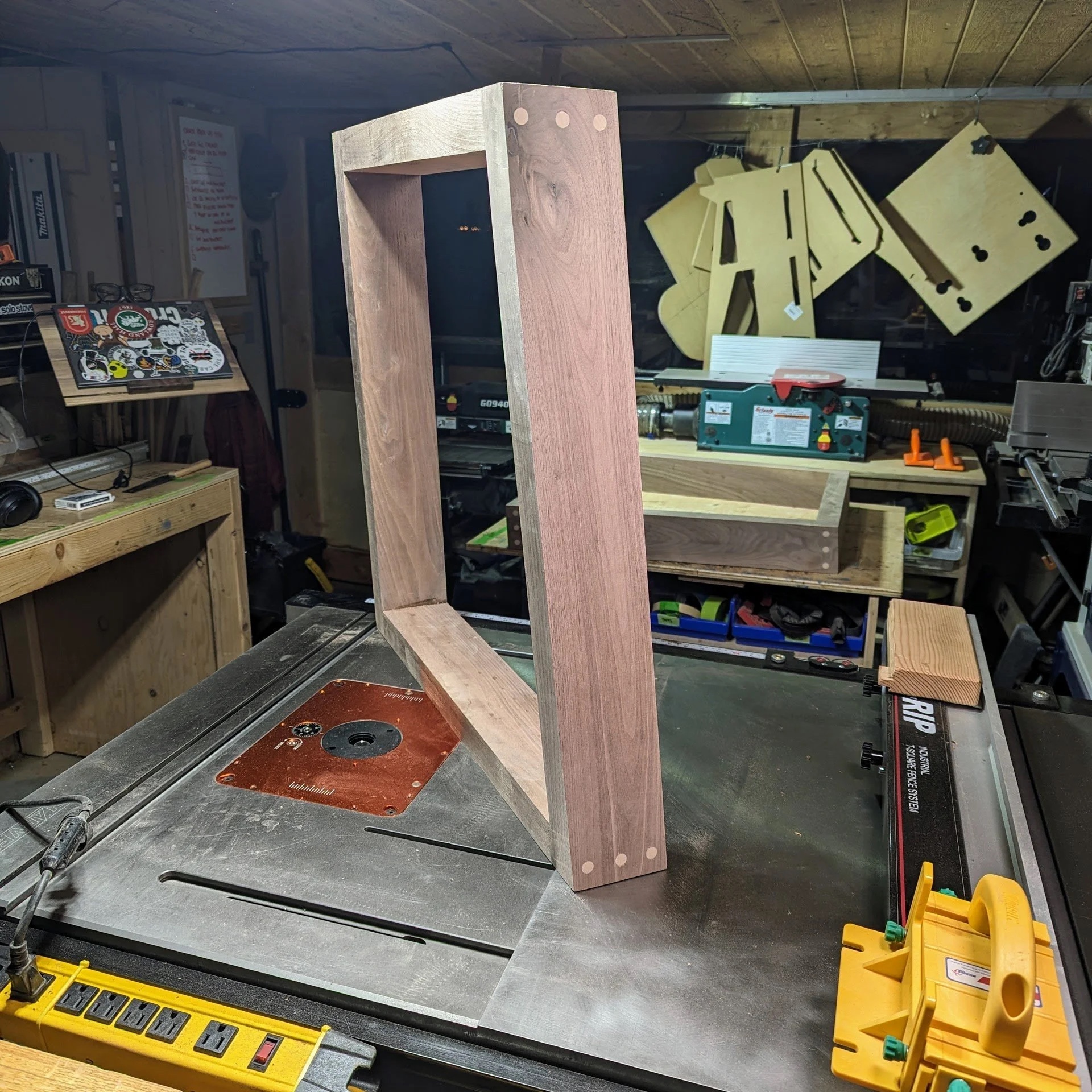 Completed leg frame on table saw — trapezoid geometry locked in