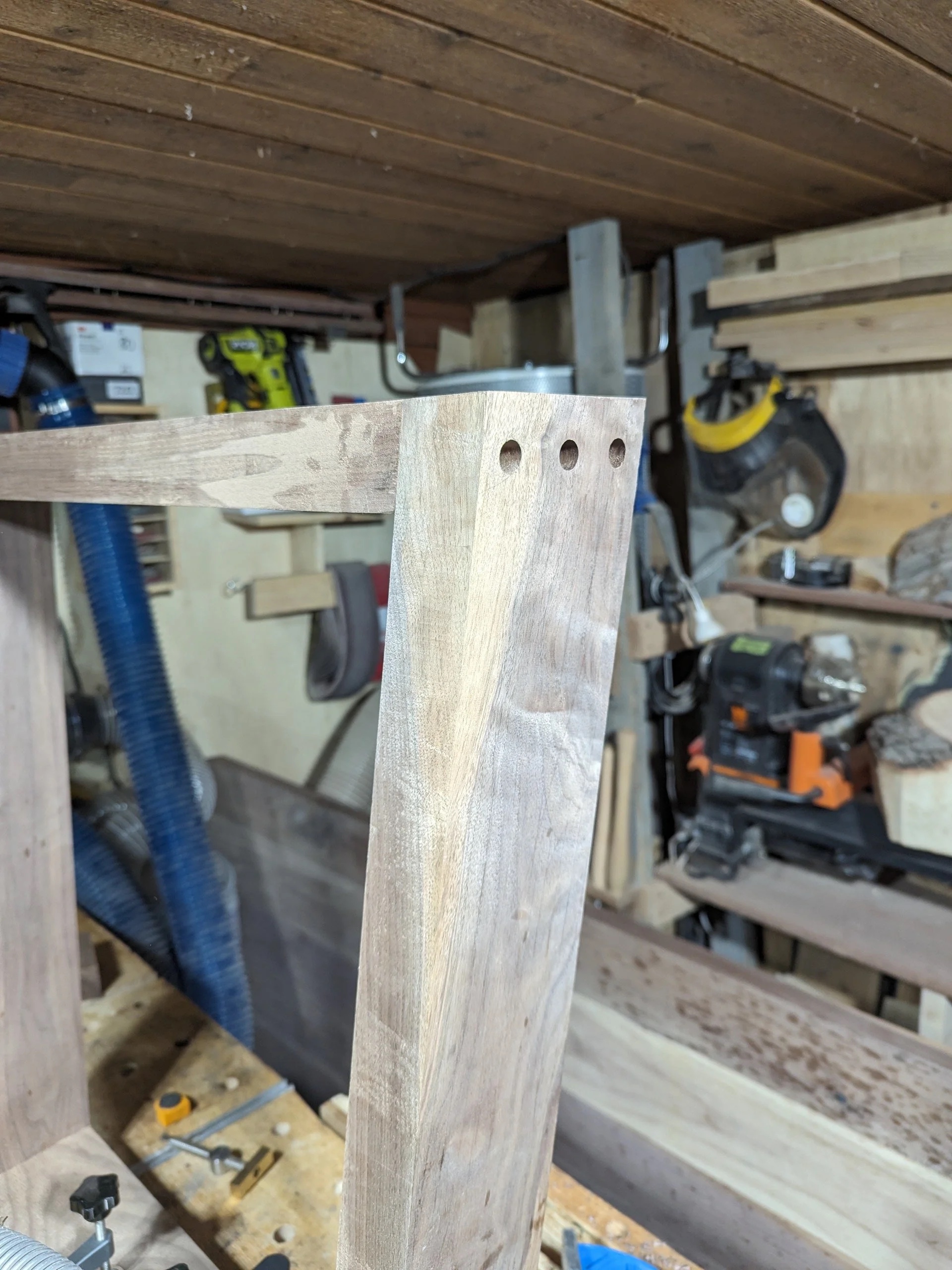 Walnut leg with dowel holes drilled — precision layout