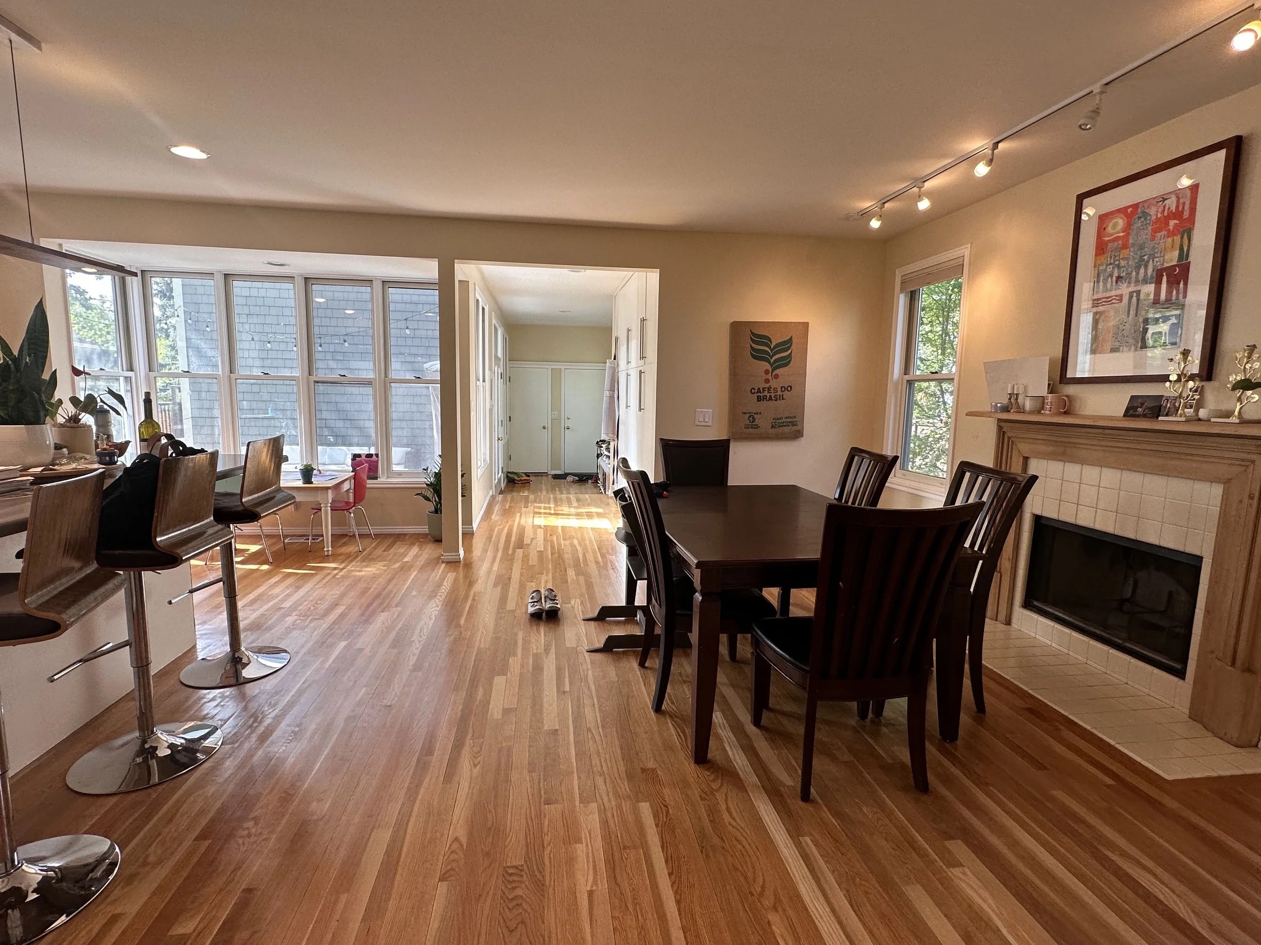 Brittney's dining room before — dark table that had seen better days, beautiful light wood floors and fireplace
