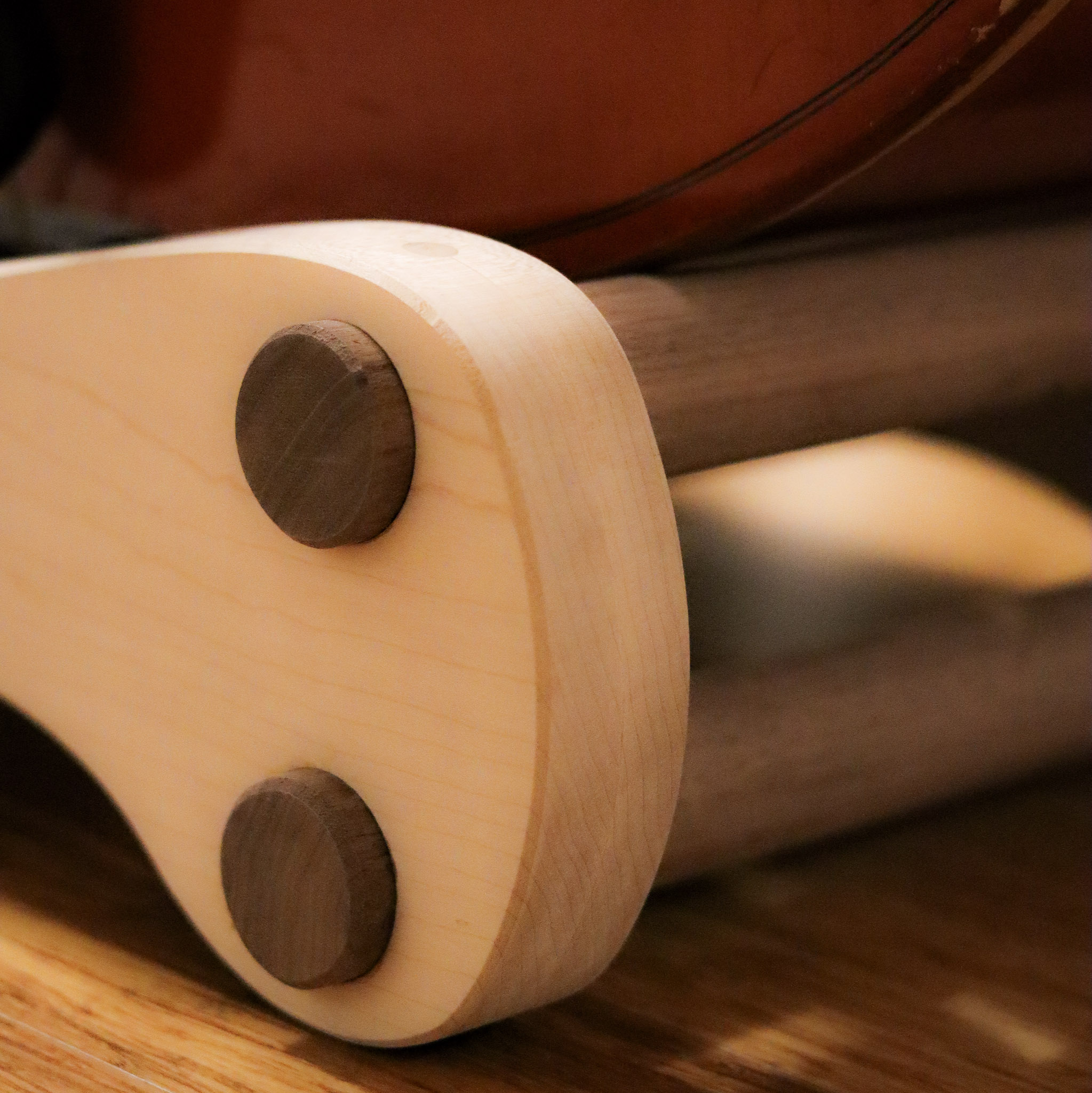 Maple panel with walnut dowel end-grain circles — the finished bass stand detail