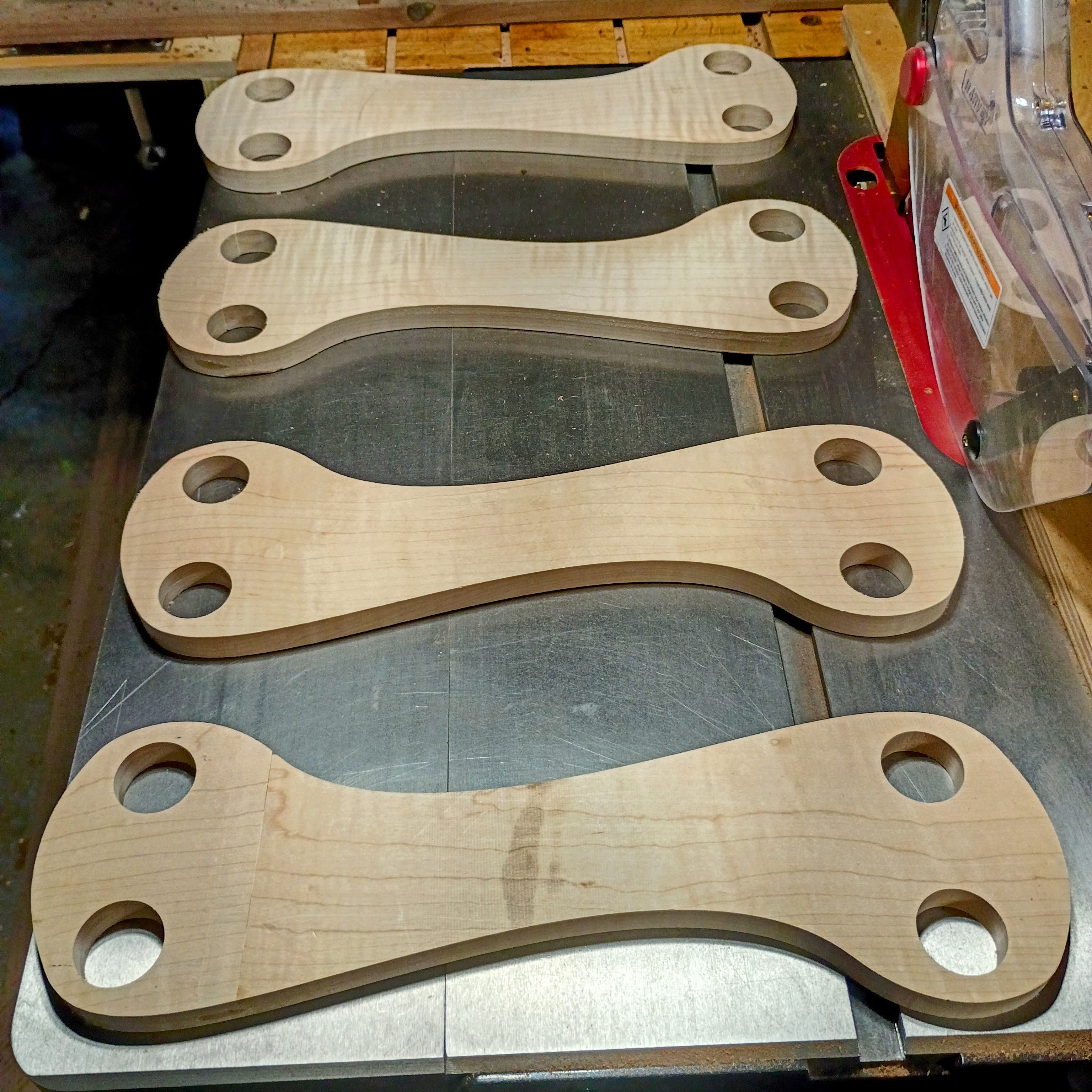 Four CNC-cut asymmetrical maple panels with dowel holes