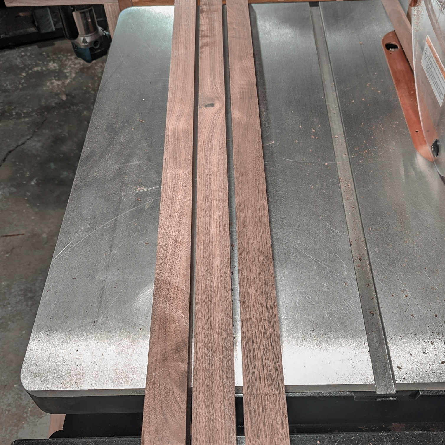 Three walnut strips on the table saw