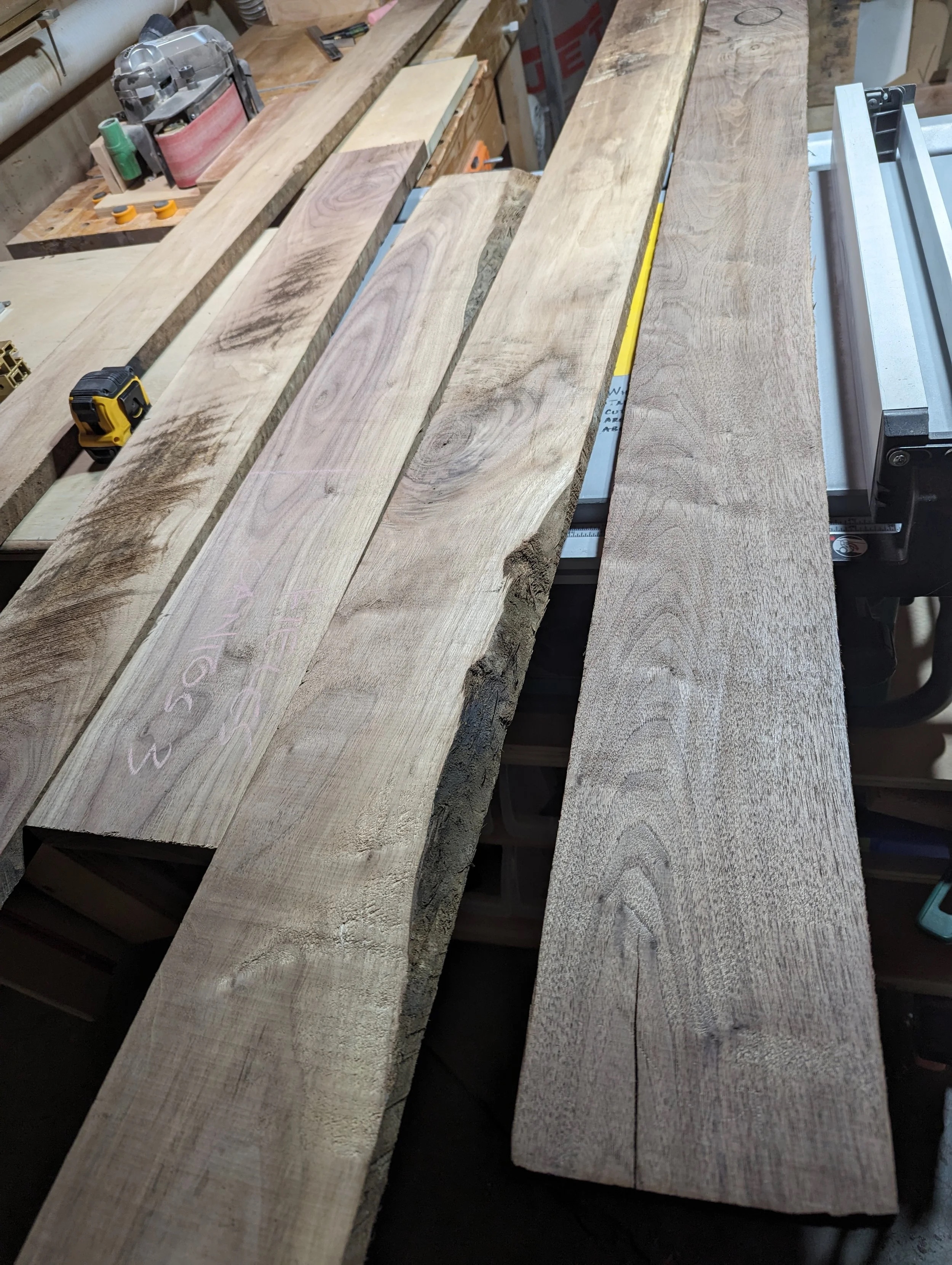 Raw walnut boards in the workshop — planning grain direction