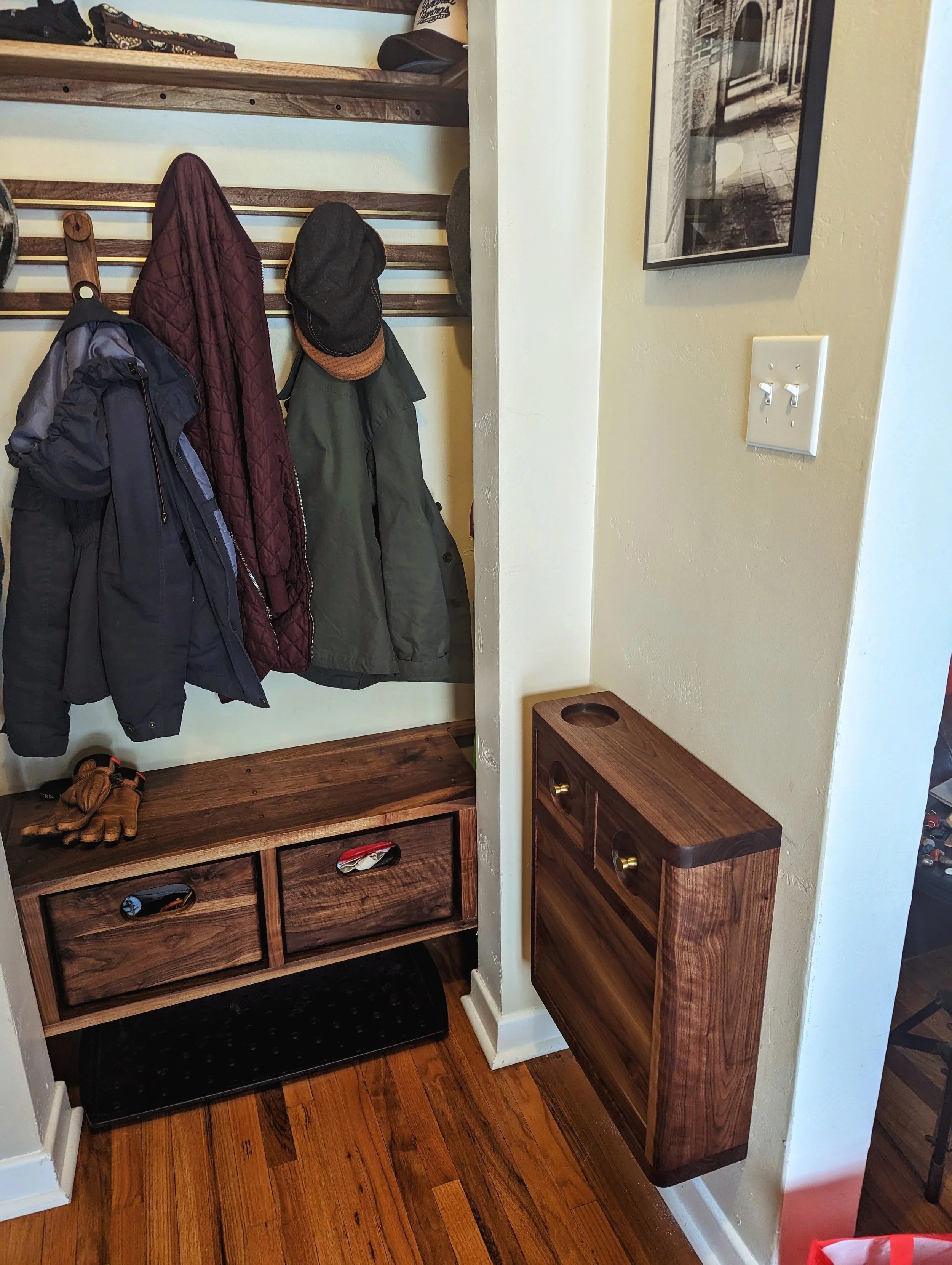 El Guardarropas installed — the complete entryway system with coats, crates, and the Owl cabinet