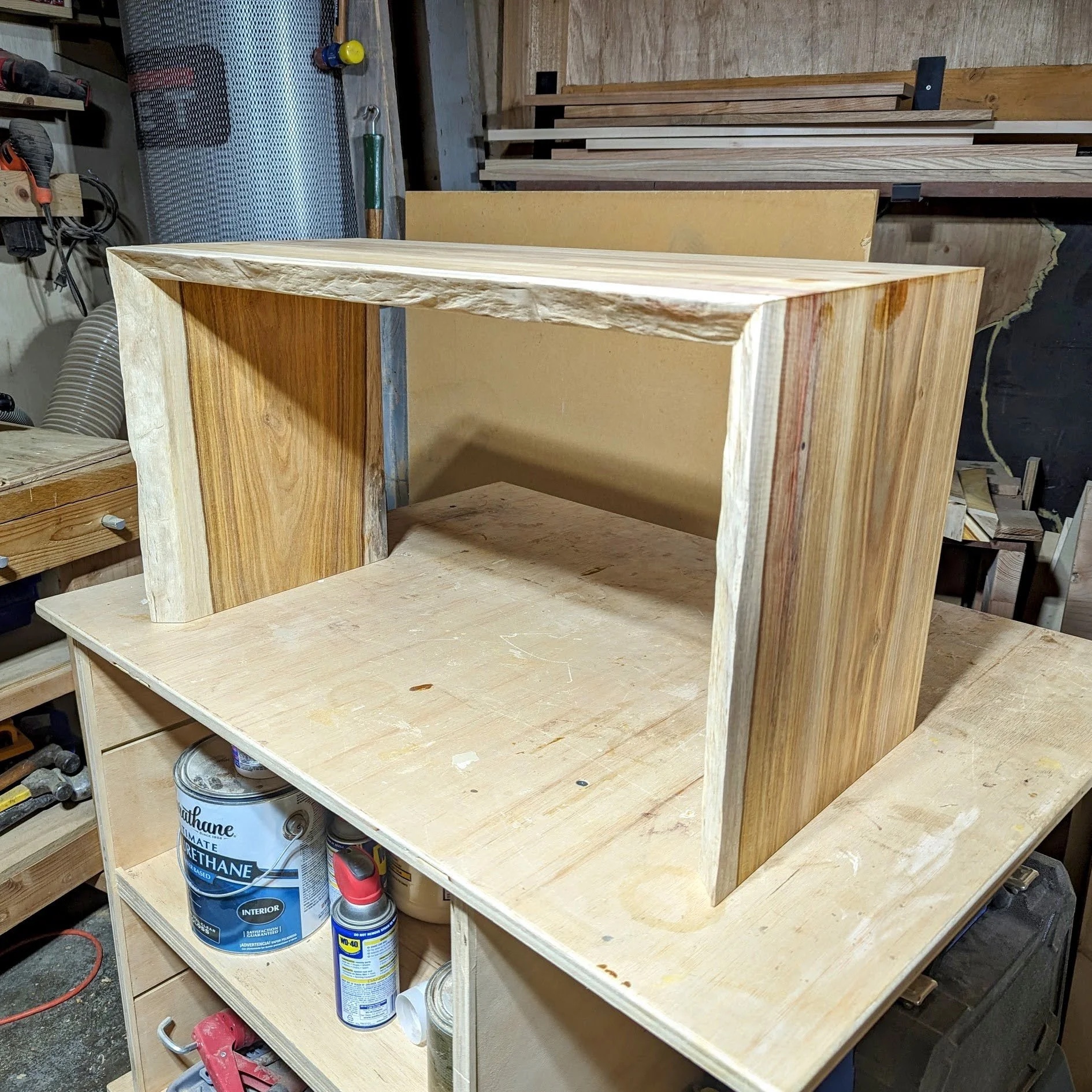 Unfinished table in workshop showing waterfall form and live edge