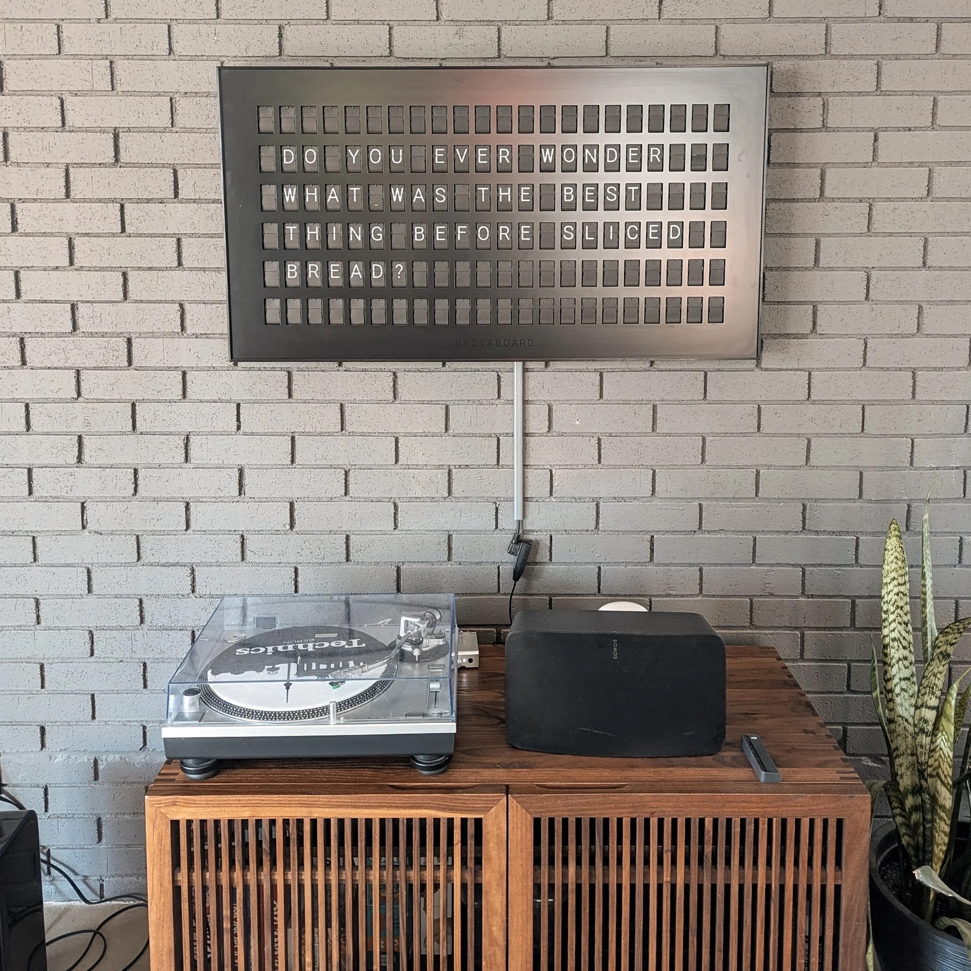 The original setup — Technics 1200 turntable, Sonos speaker, and Vestaboard mounted above the tiny credenza