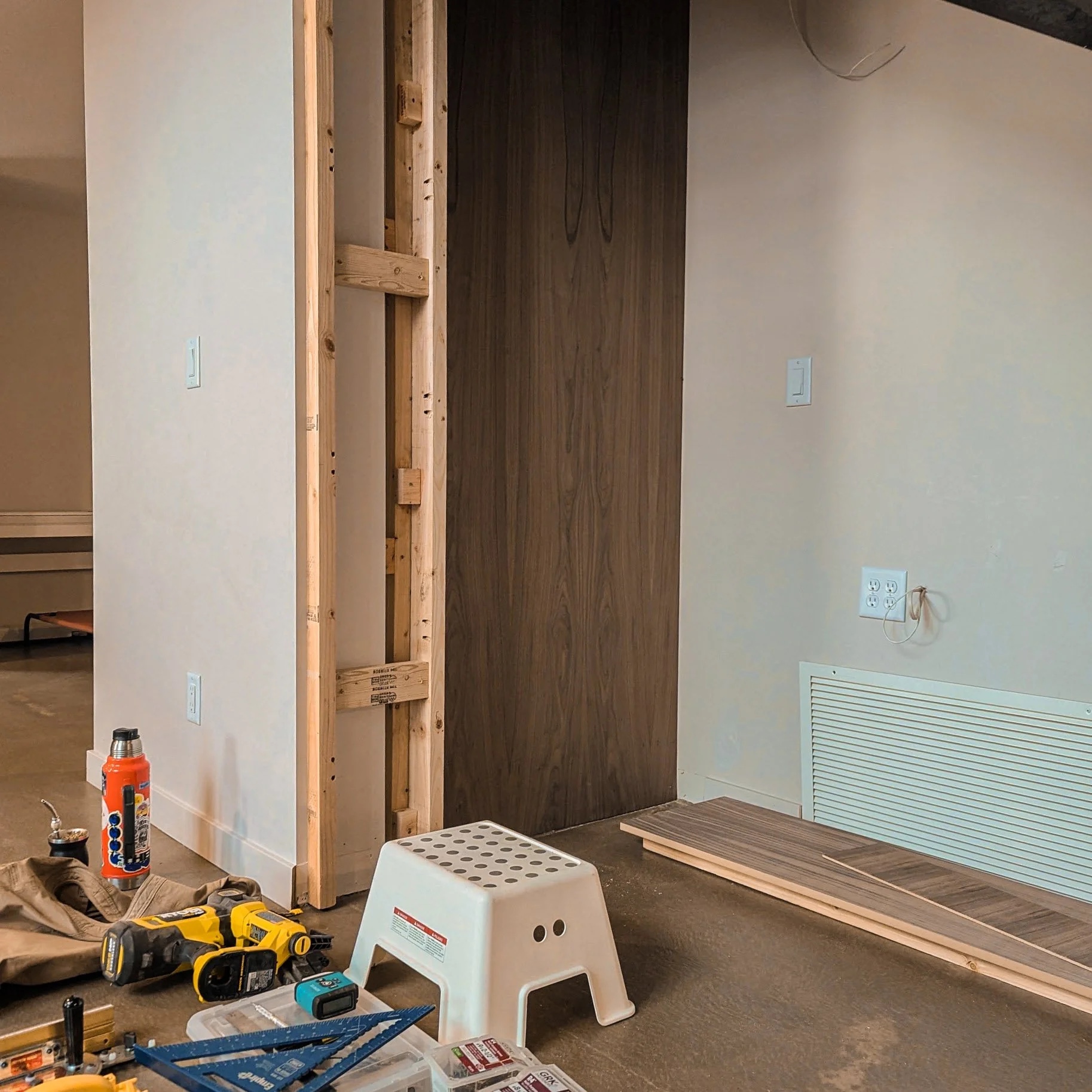 Pine framing and MDF panel installation under the staircase — tools scattered on the floor