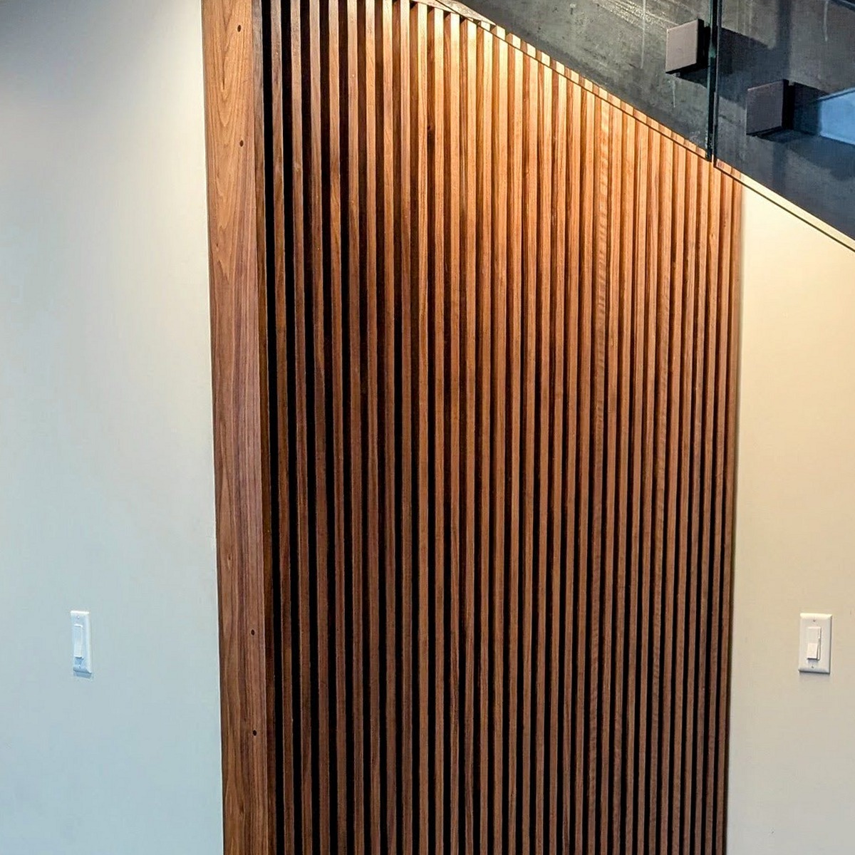 The Nook — walnut slatted sliding door hiding a wine closet
