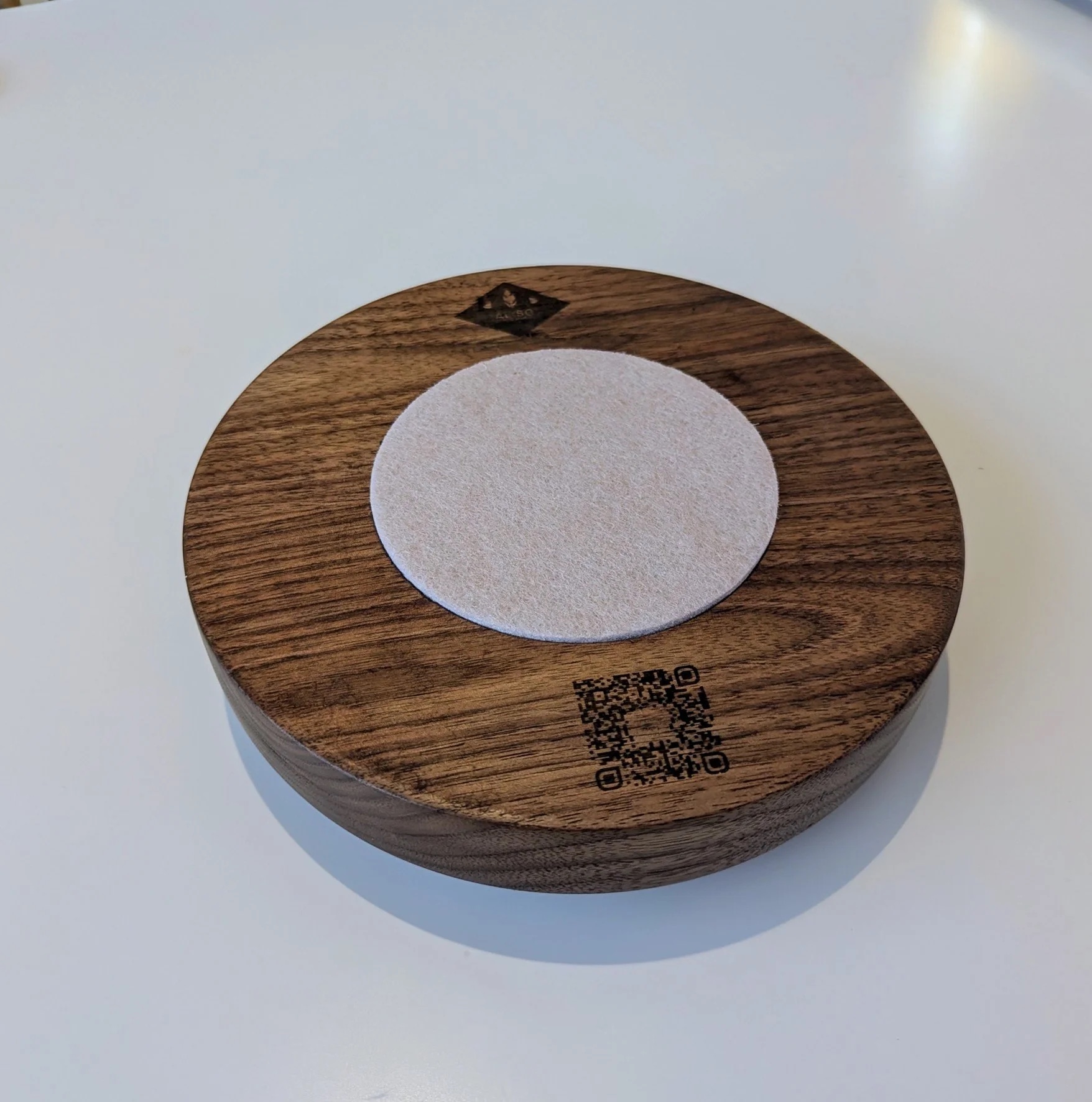 Bottom of walnut base showing ALISO brand stamp, QR code, and felt pad