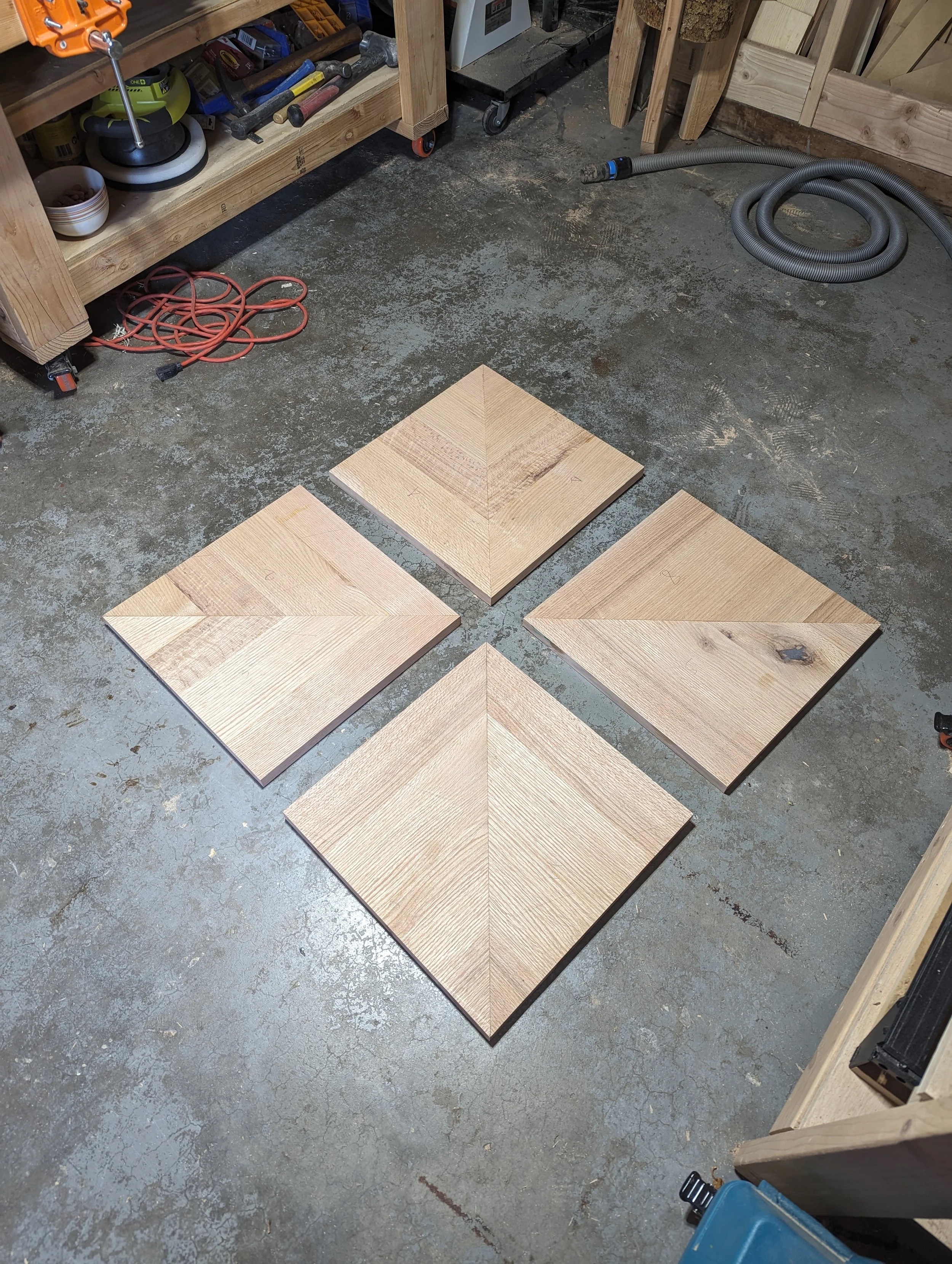 Four chevron quadrants laid out on the shop floor — grain aligned