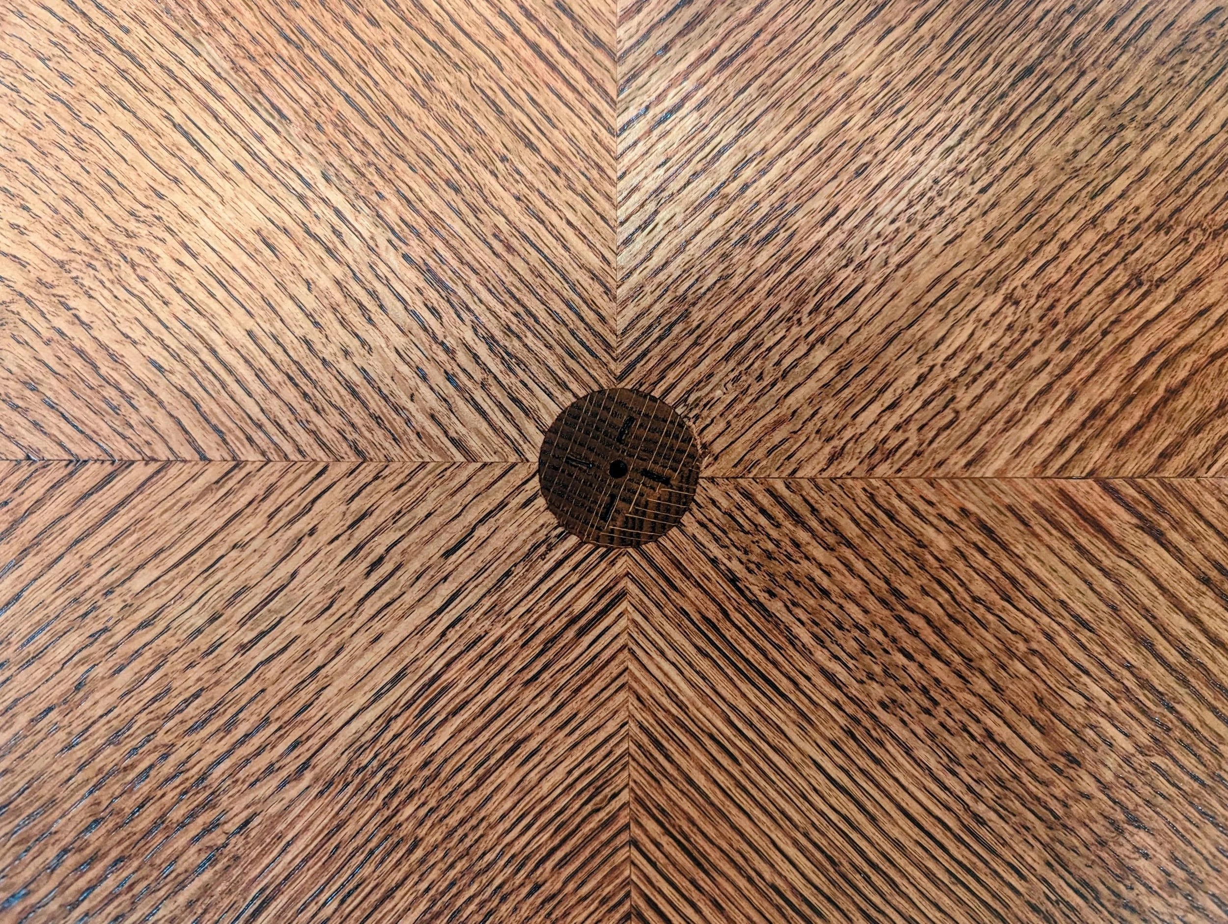Close-up of the chevron center — tiger grain revealed under cherry stain