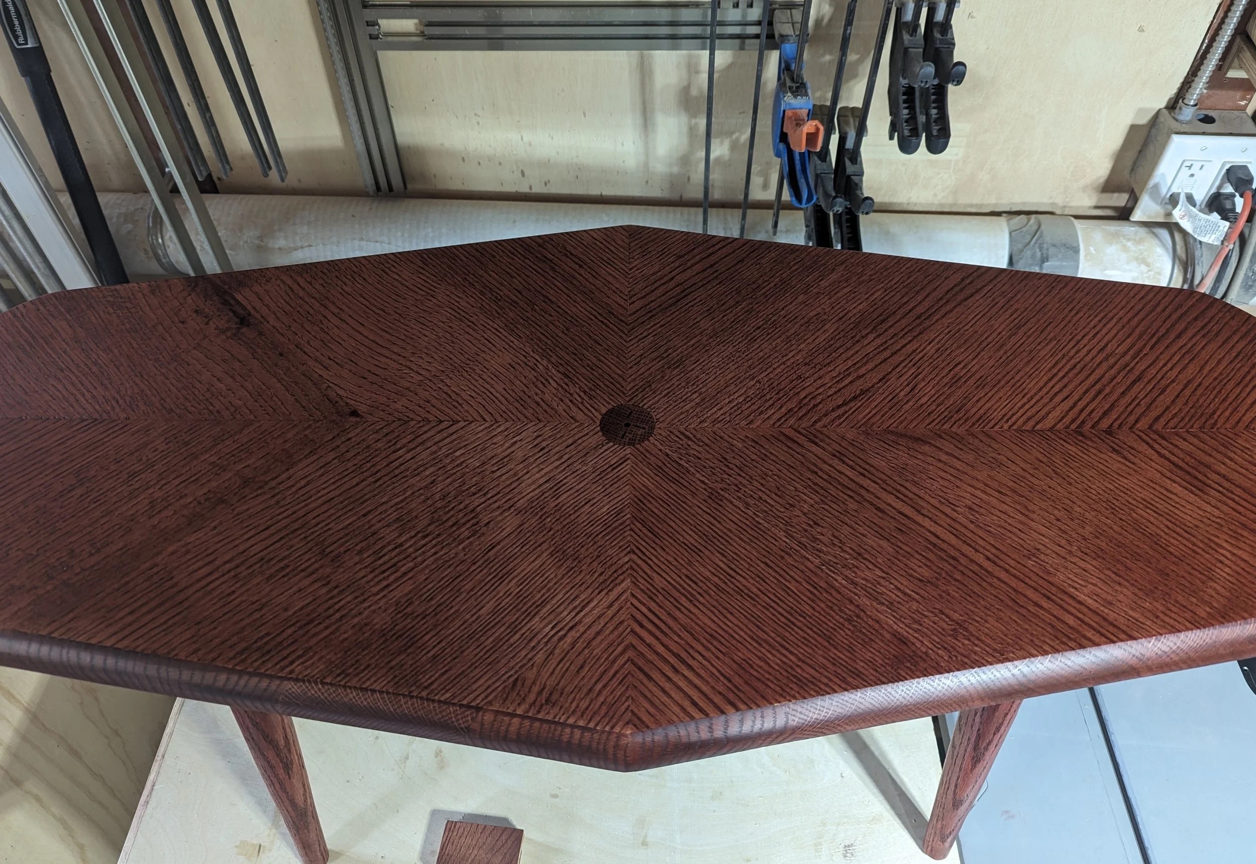 The stained tabletop from above — full chevron pattern with tiger grain under cherry stain