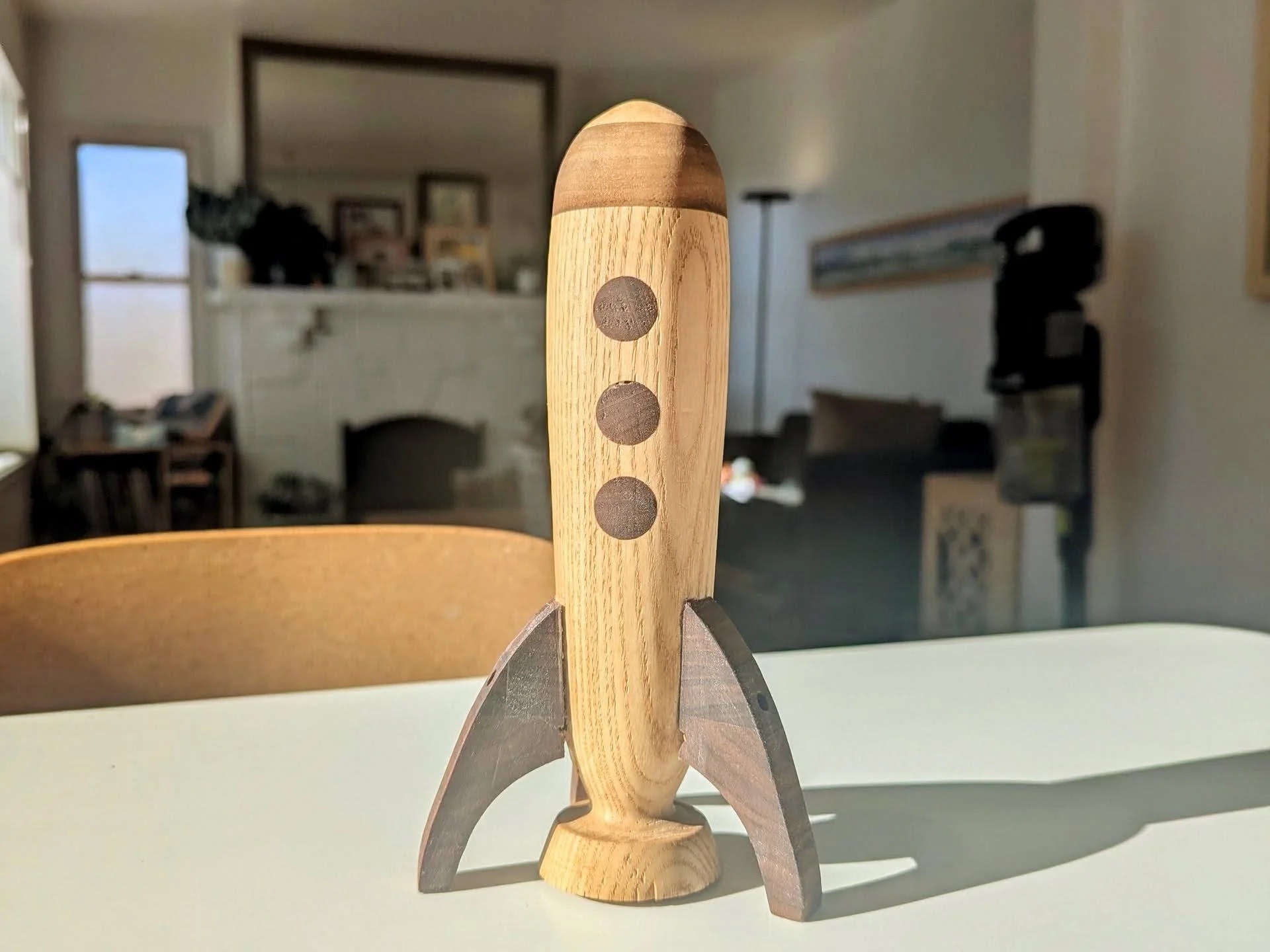 First rocket prototype — ash body with walnut fins on workshop table