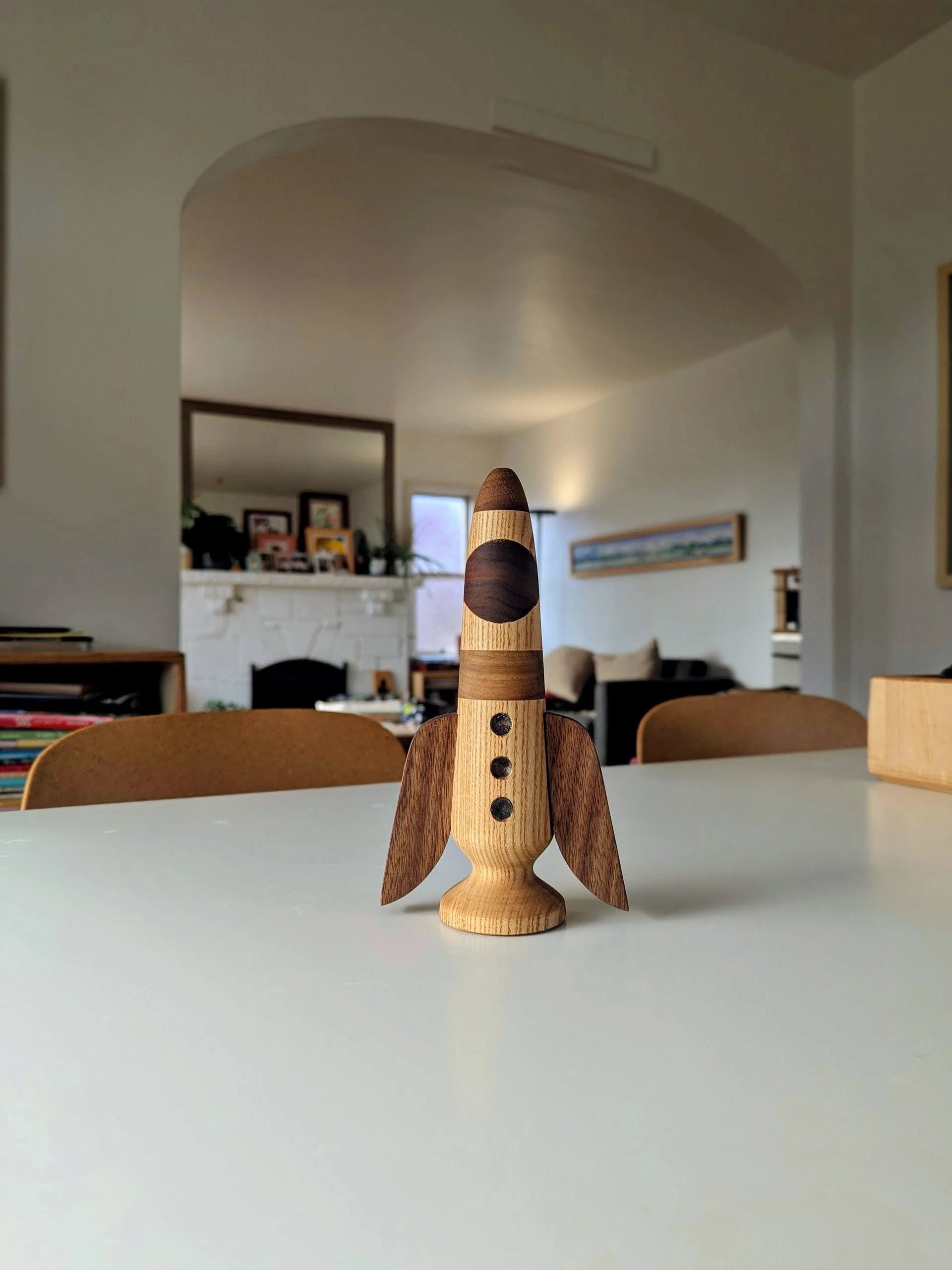 The Rocket — lathe-turned wooden rocket toy in ash and walnut