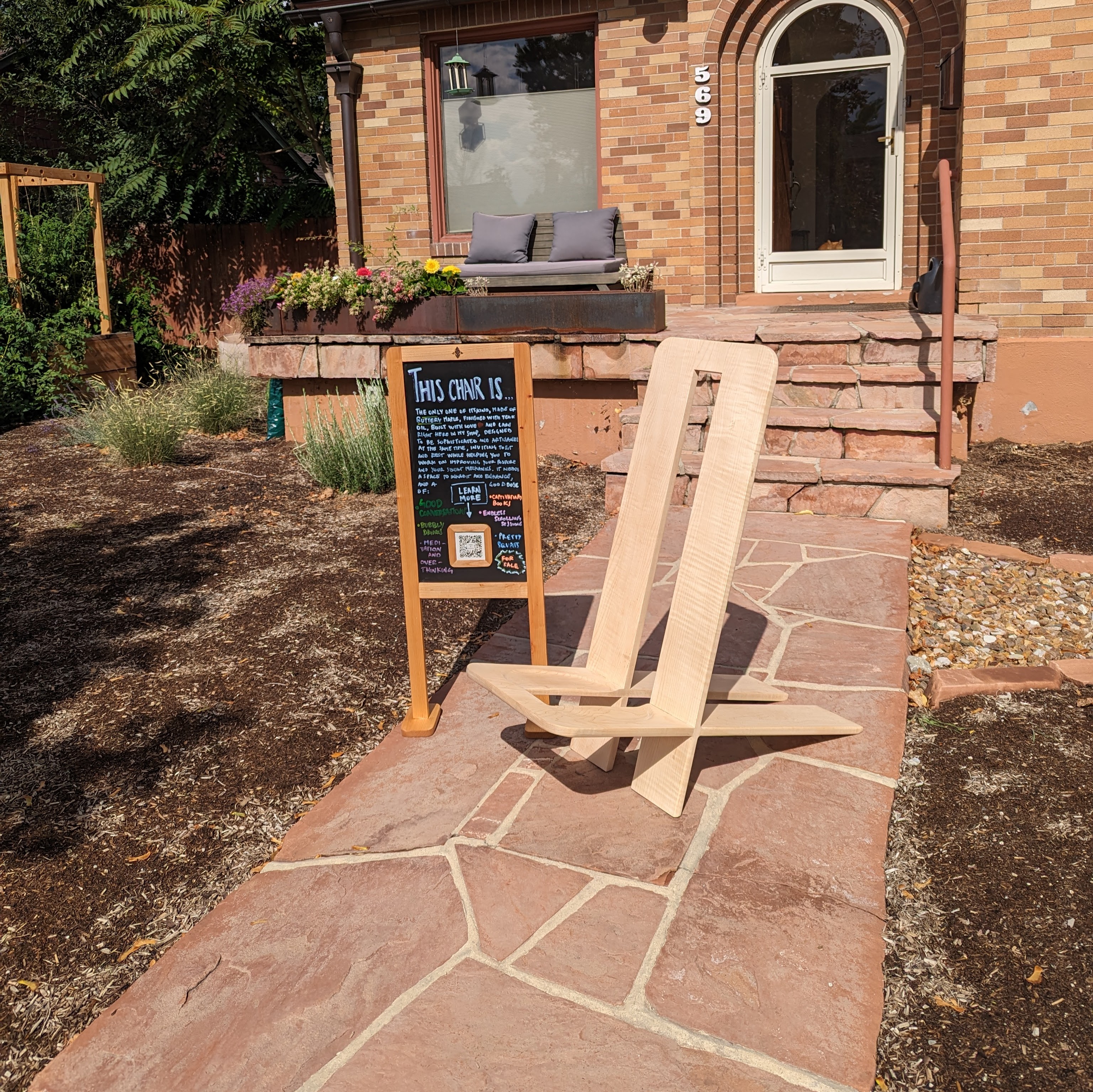 The Squatting Chair — a marketing experiment with a blackboard and QR code on the front walkway