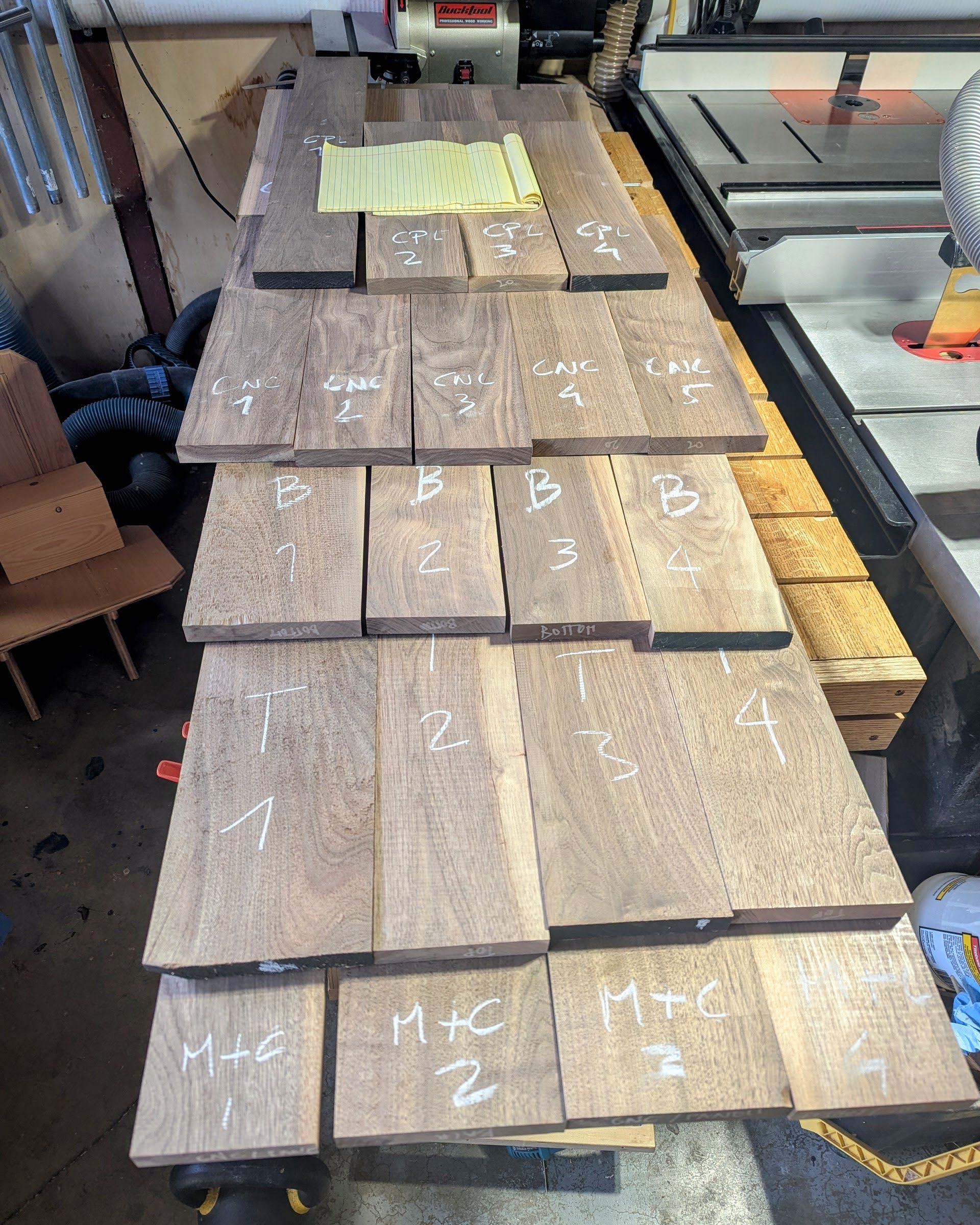 The CNC-door panel being assembled — the cleanest strips reserved for the piece that will carry the speaker-grille pattern