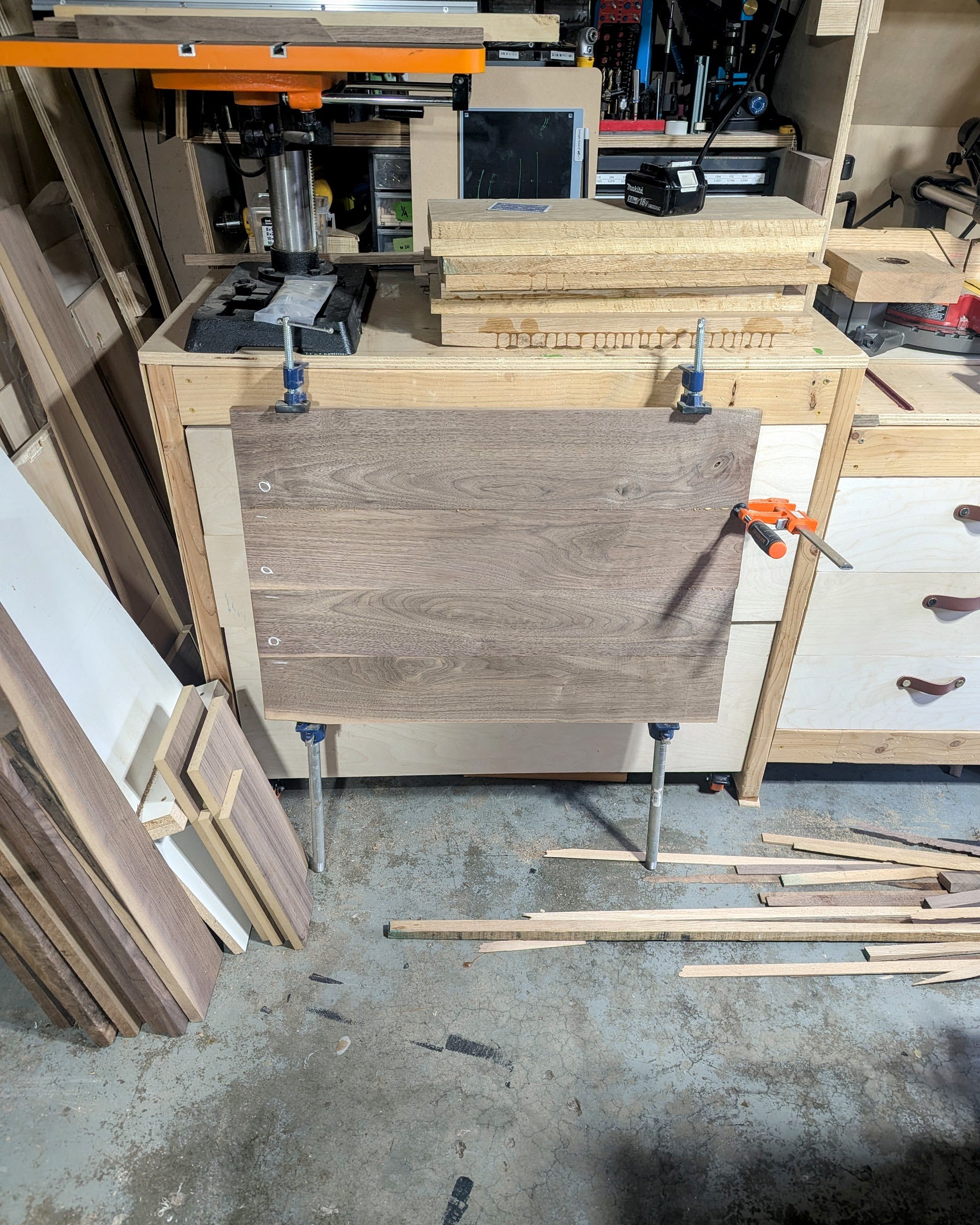 Panel glue-ups underway — bar clamps across the stack as the boards become a single surface