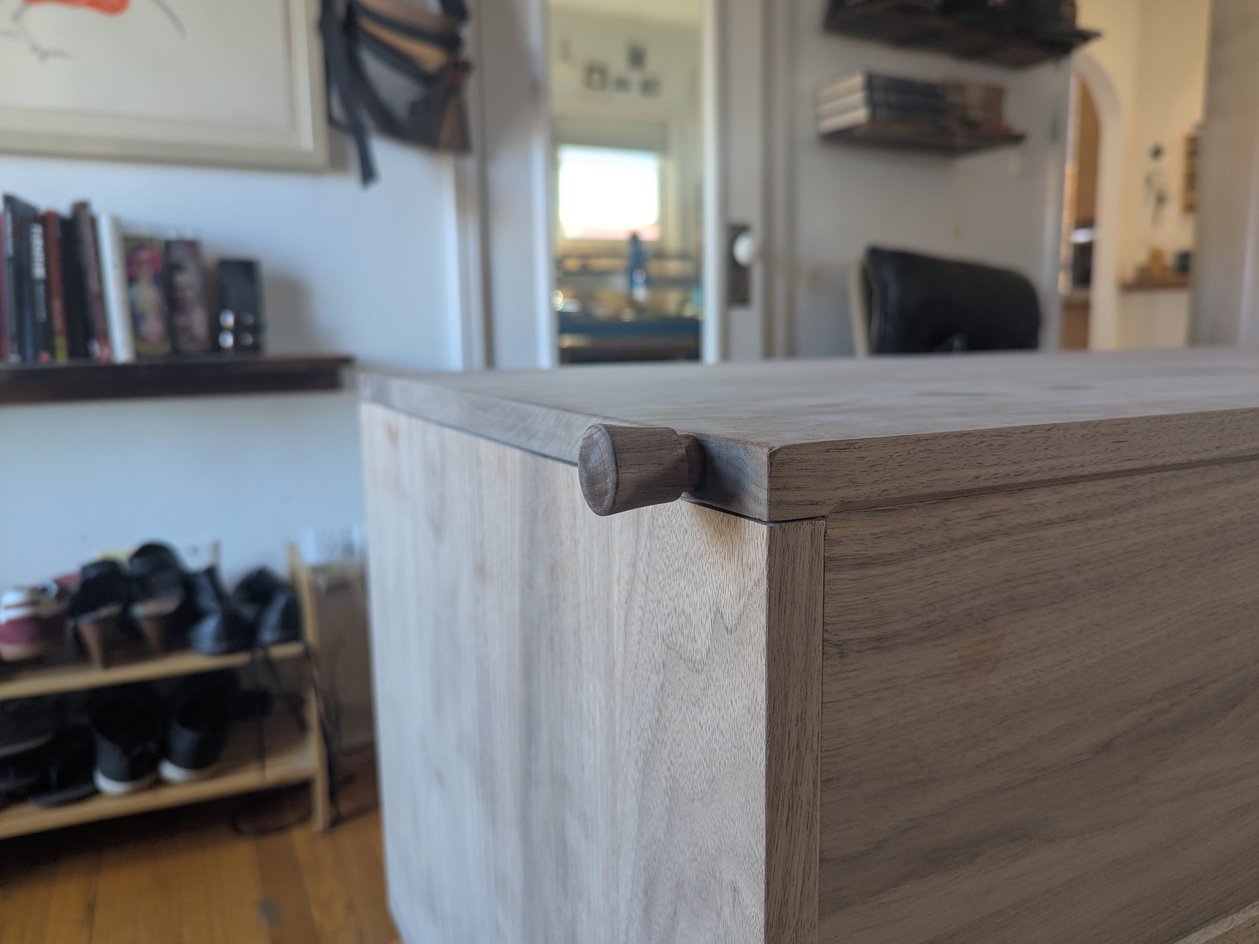 El botoncito — a small walnut knob turned on the lathe and fitted where the lid meets the carcass, the first thing your hand finds