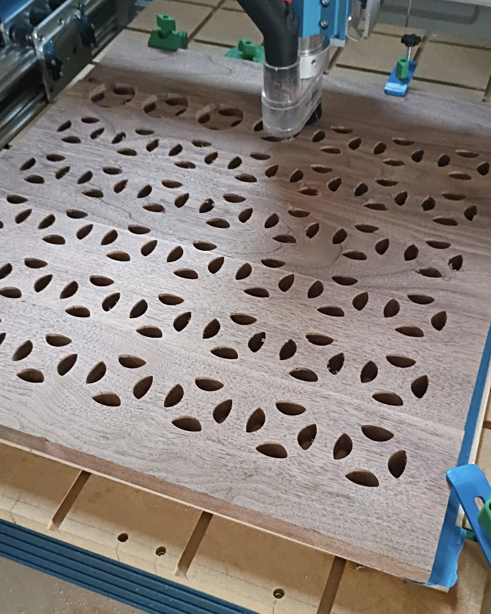 Hours later: the full field of openings roughed into the walnut, spindle still running