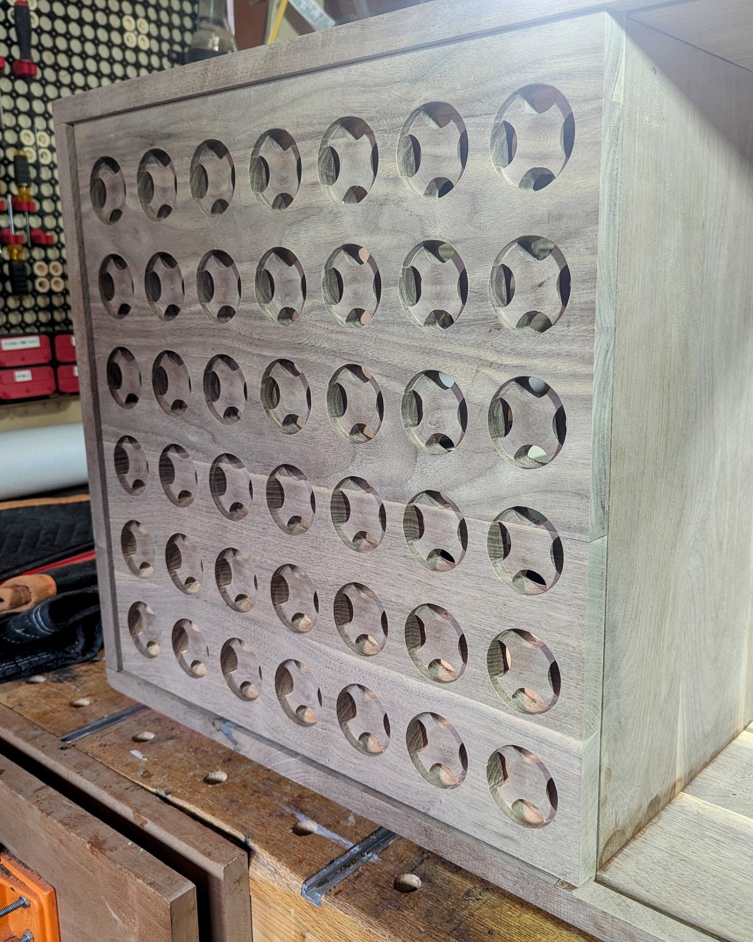 The finished speaker-grille door up close, six rows of openings in walnut