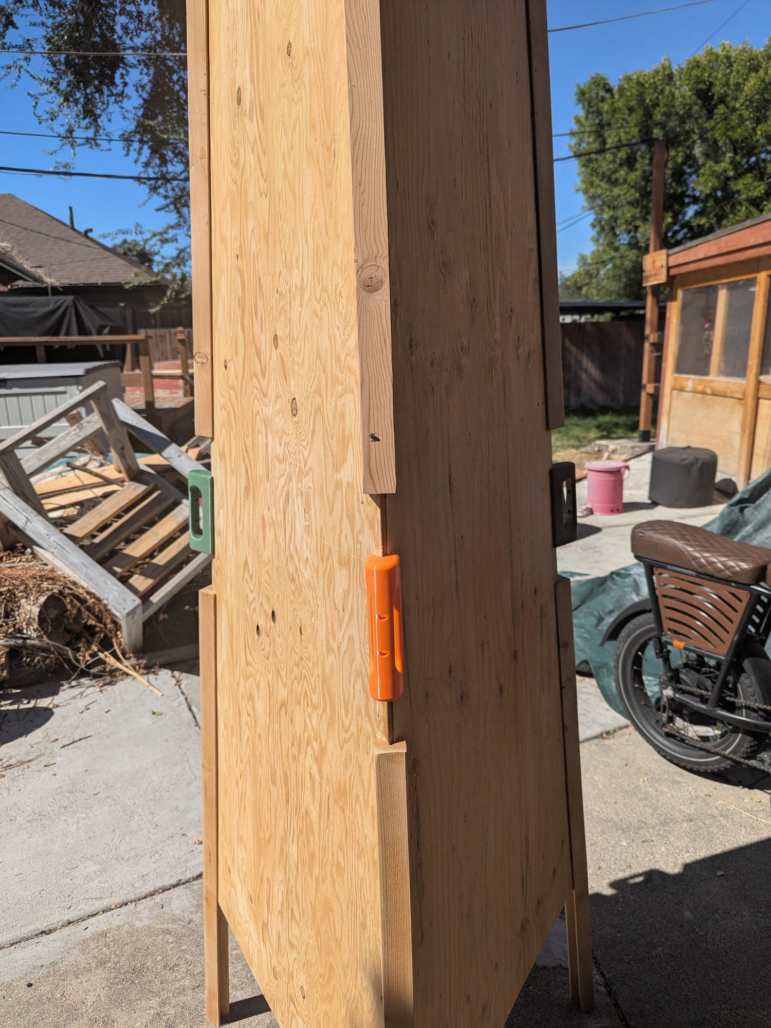 Side view of the plywood prototype showing the orange handles on the panel