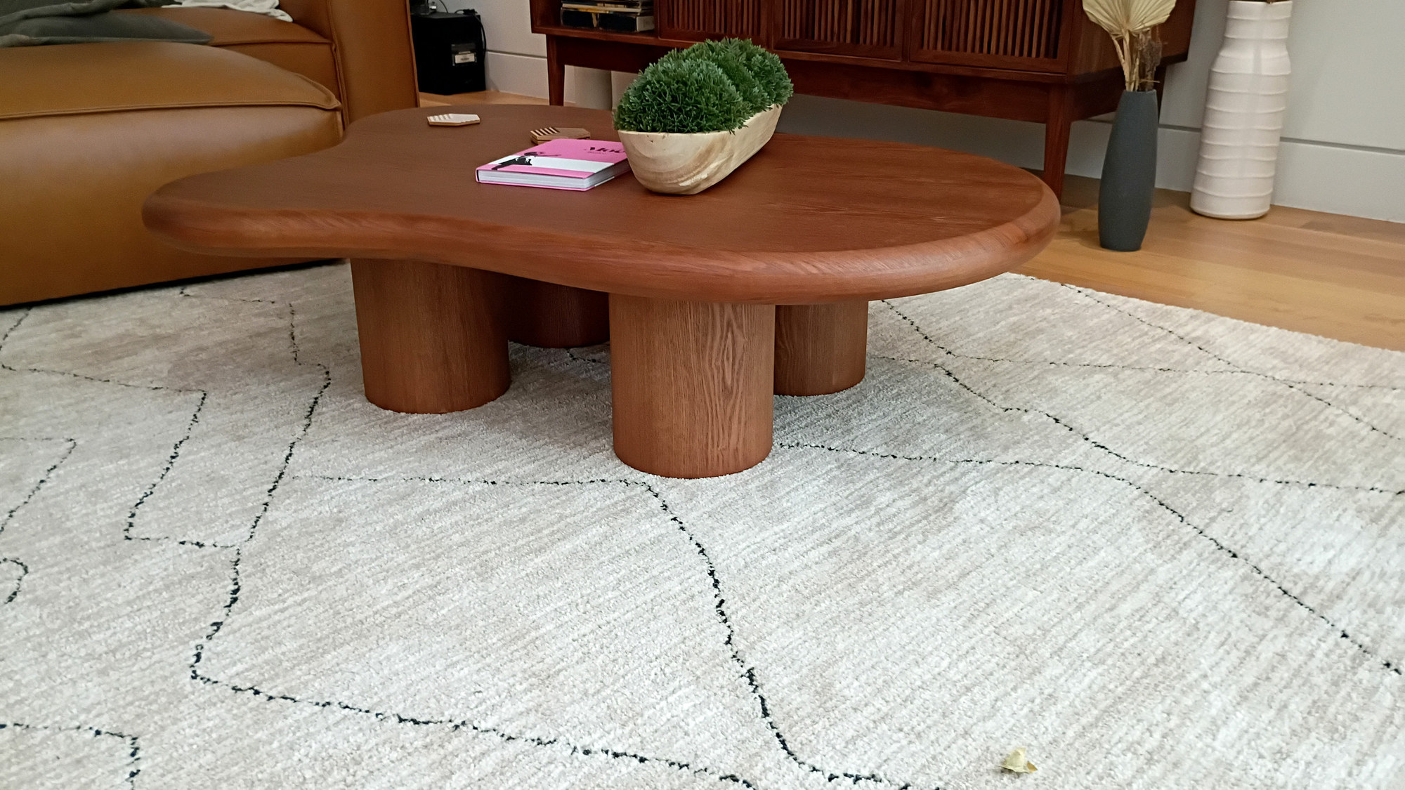 The clients' pod-legged coffee table, soft organic curves in warm wood