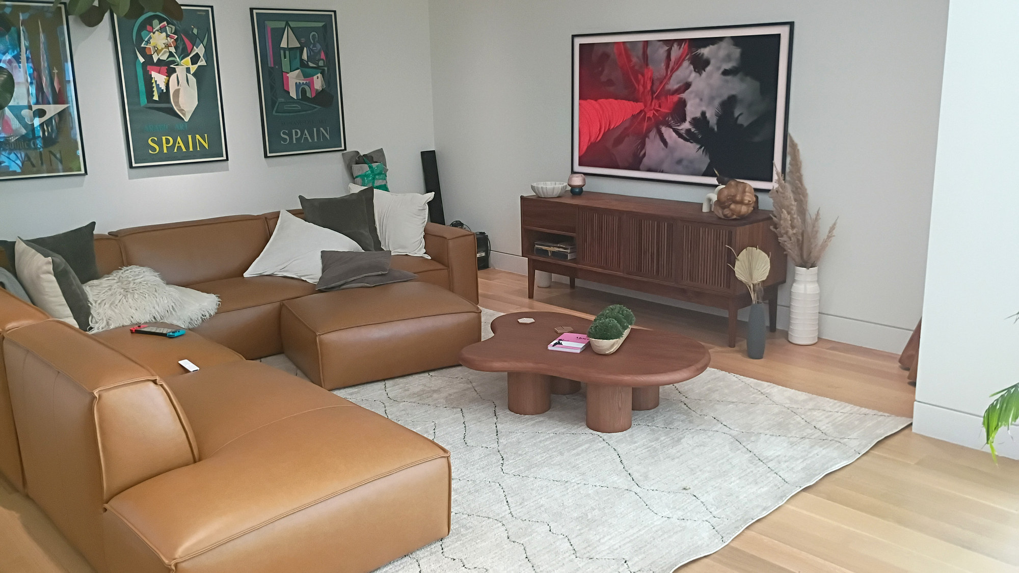 Ali and Eduardo's living room: leather sectional, pod-legged coffee table and the slatted walnut credenza