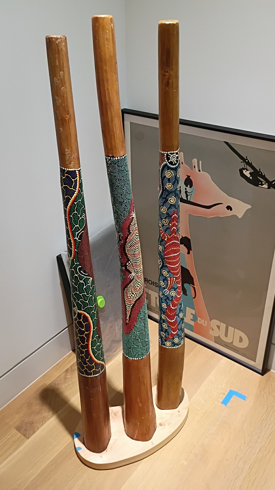 Three painted Yidakis standing upright in the softwood prototype base